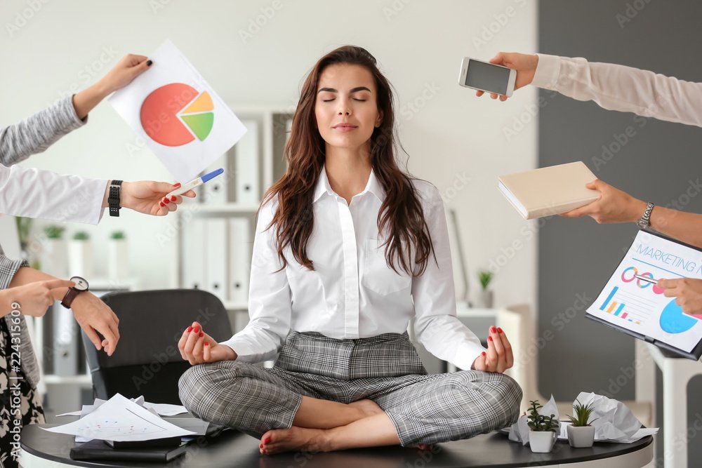 Businesswoman with a lot of work to do meditating in office